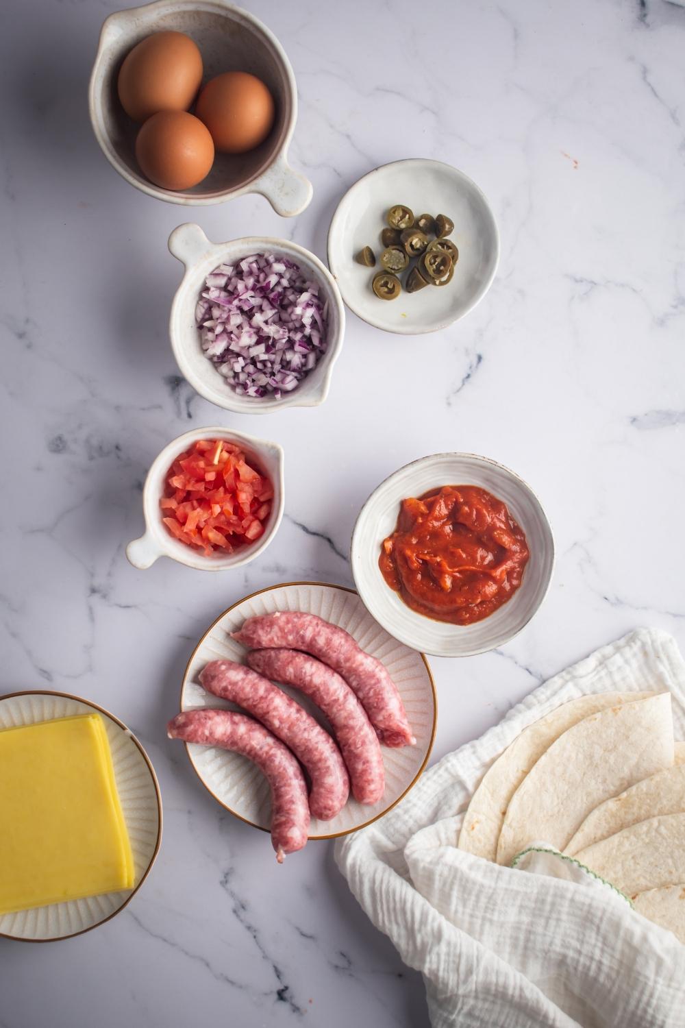 For sausage links on a plate, a bowl of salsa, bola tomatoes, a bowl of purple onion, I'll play with jalapeños on it, and a bowl with three eggs in it.