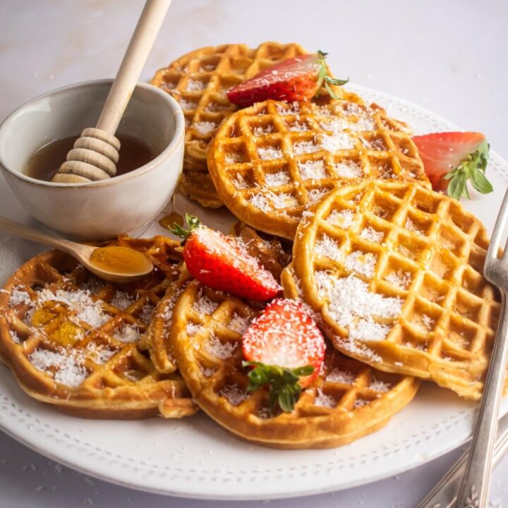 How are you play with a bunch of waffles on it and a bowl with honey in it.