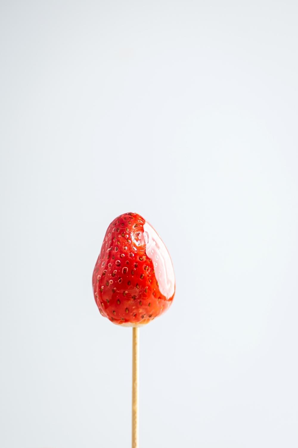 A wooden stick with a strawberry on it.