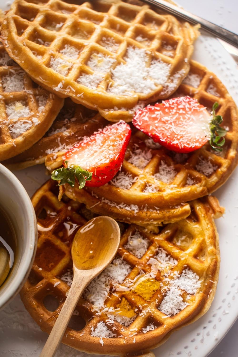 Three waffles overlapping one another on a white plate.