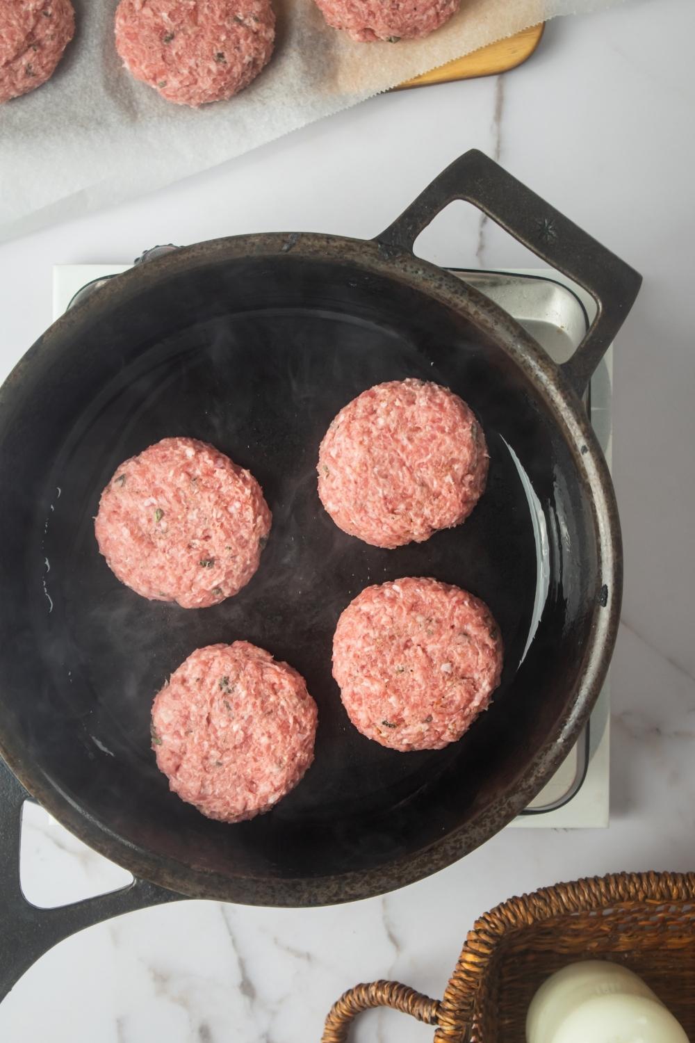 An overhead view of a skillet cooking for Jimmy Dean patties.