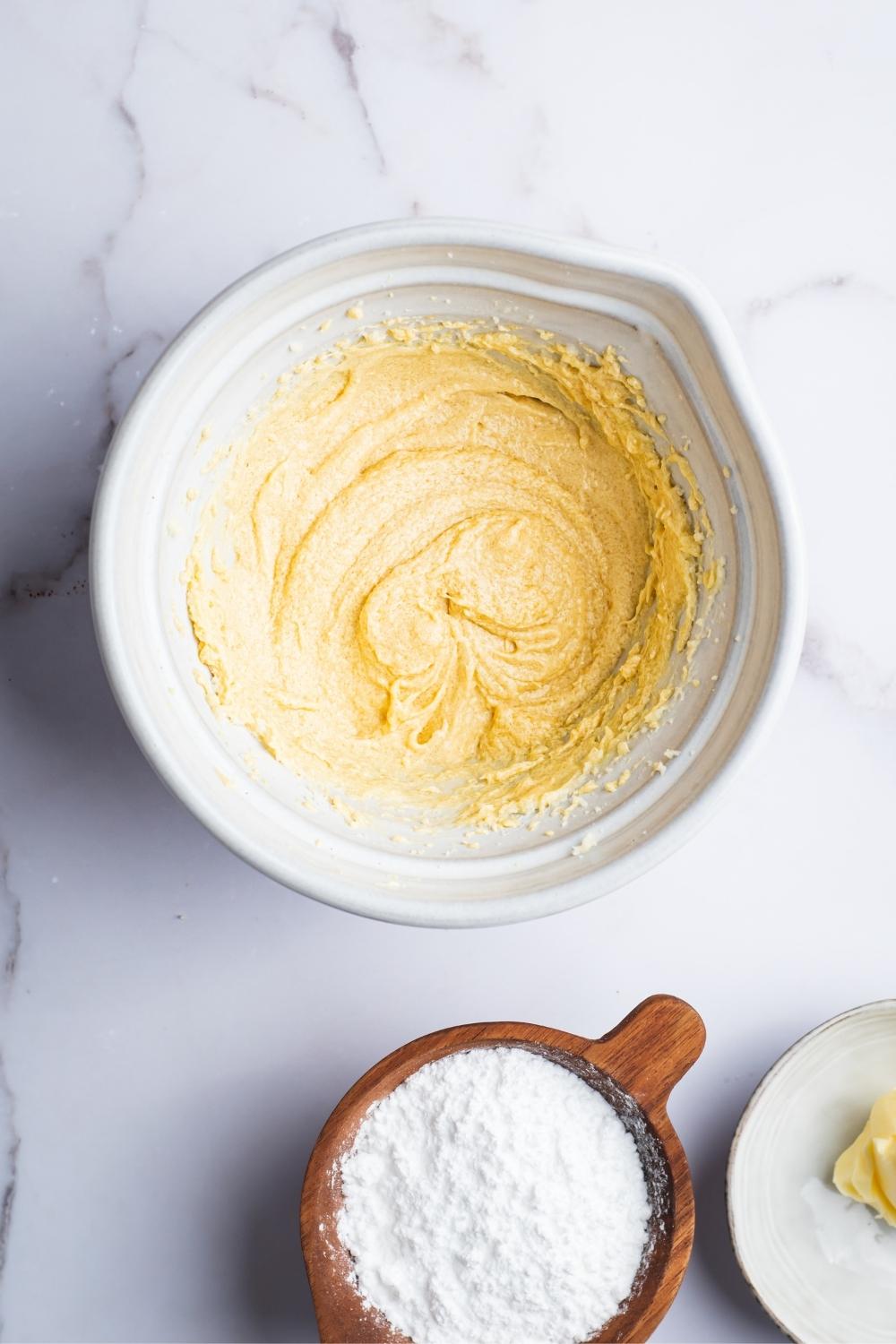 An overhead view of a large bowl with creamed butter and sugar in it.