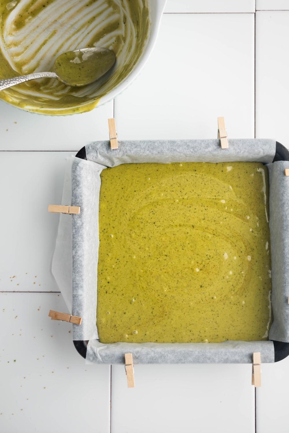 A brownie pan that is filled with matcha brownie batter.