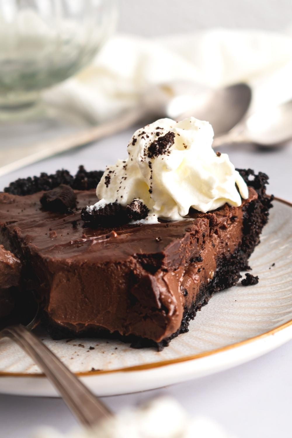 Mississippi mud pie on a white plate with a bite taken out of the front of it.