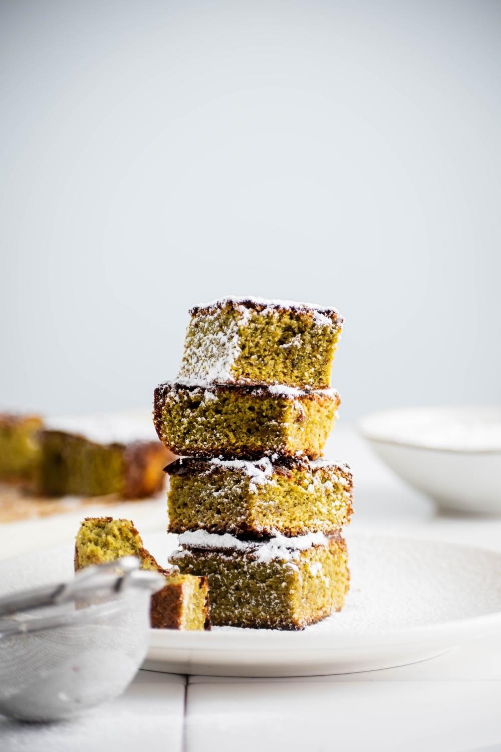 A stack of matcha brownies on a white plate.