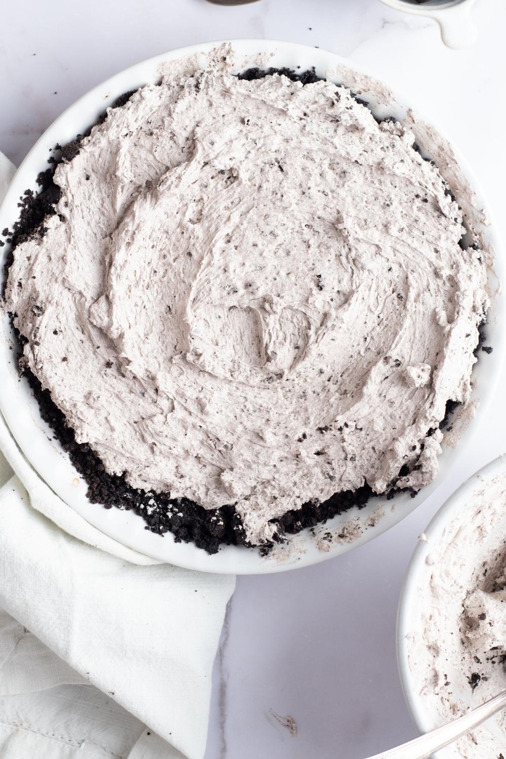 An overhead view of a homemade oreo pie filling topped on oreo pie crust.