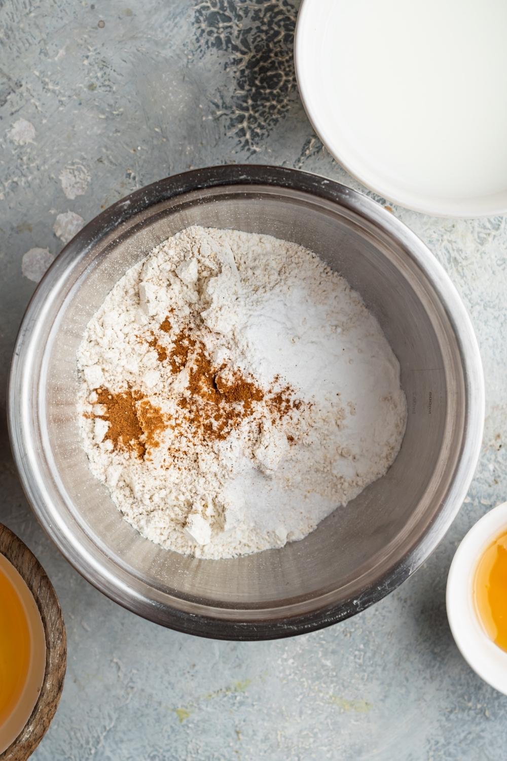 An overhead view of a large mixing bowl containing dry ingredients to make waffles without milk.