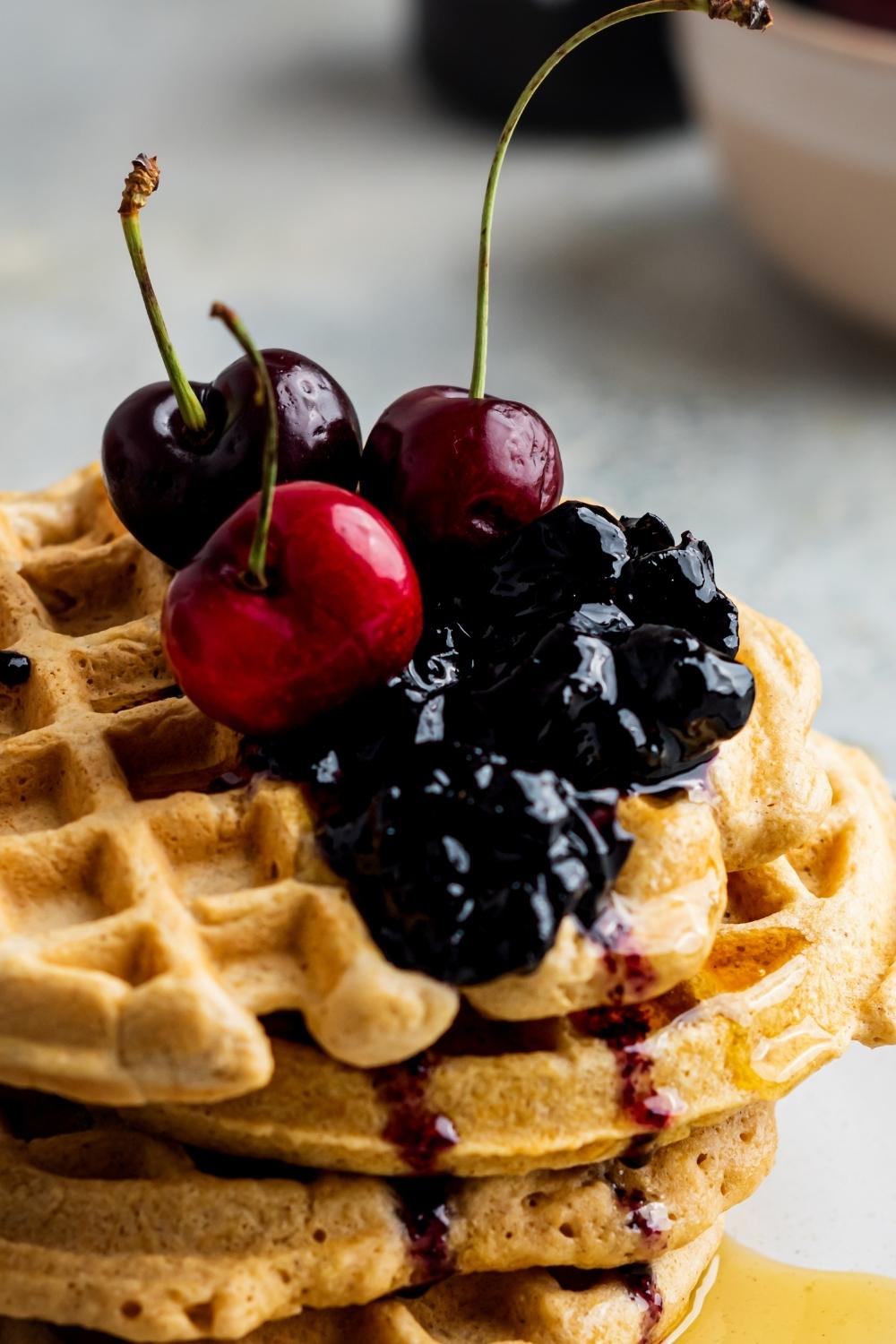a close up the berries and cherries on top of homemade waffles without milk.
