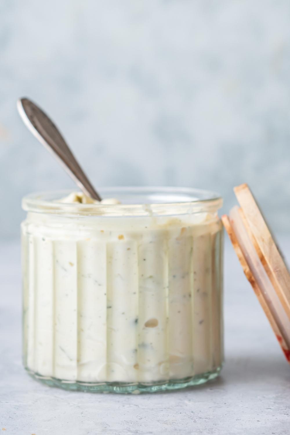 A small jar with a spoon in it containing homemade McDonald's tartar sauce.
