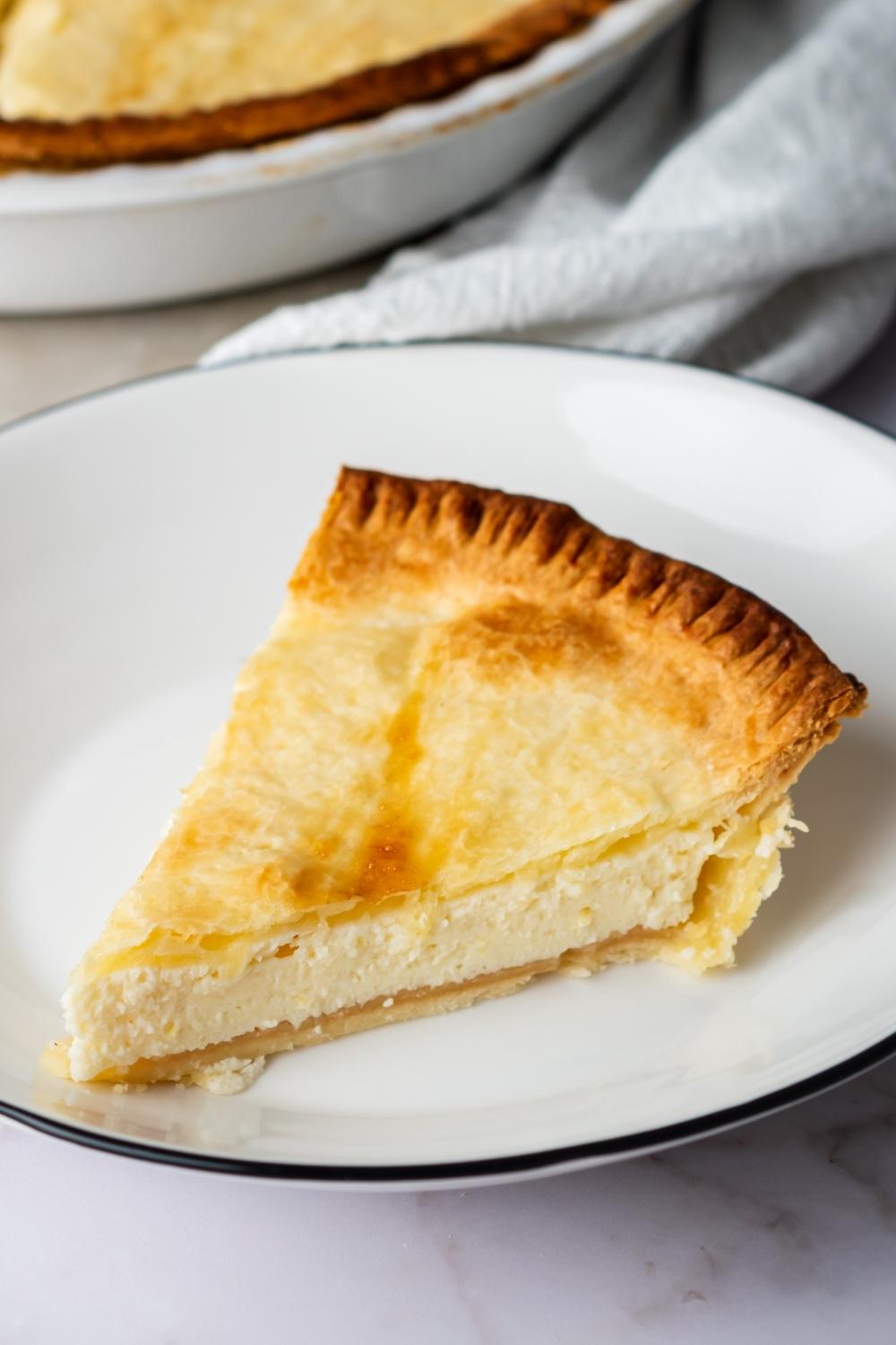 A slice of ricotta pie on a white plate.