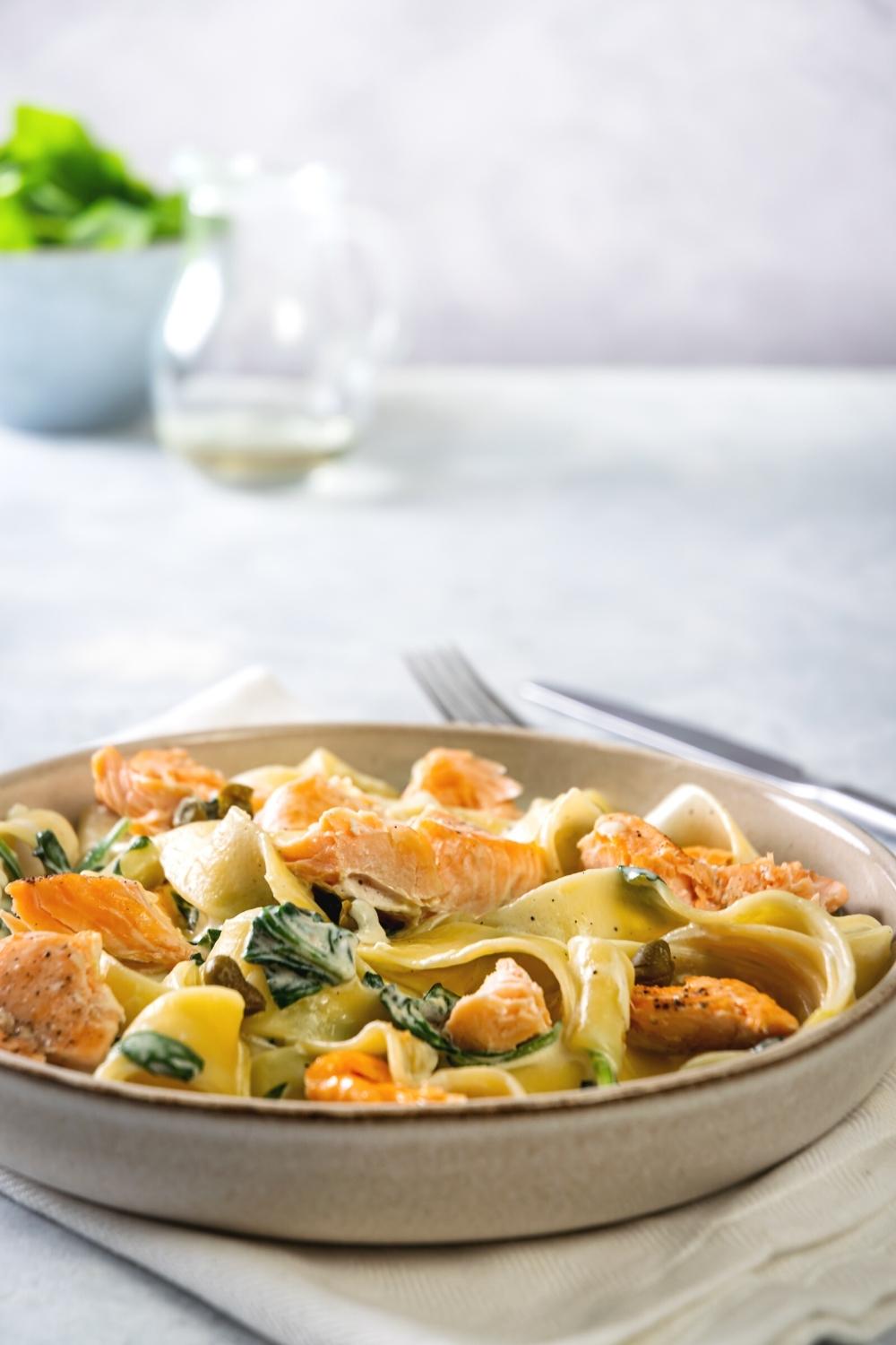 A bowl with creamy salmon pasta in it.