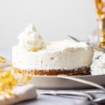 A cheesecake with graham cracker crust on a plate.