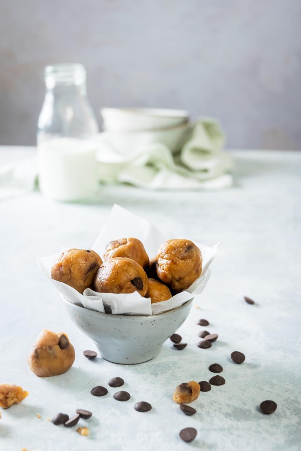 A bowl filled with edible cookie dough balls in it.