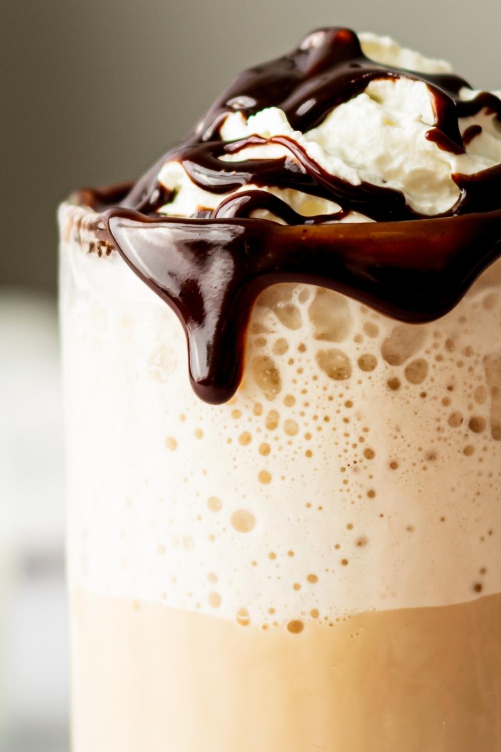 A close-up of homemade McDonald's mocha frappe topped with whipped cream and chocolate drizzle.