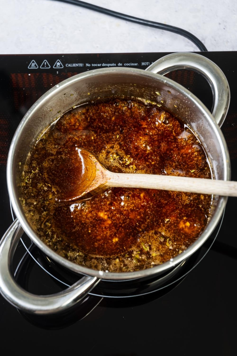 Szechuan sauce cooking in a pot on a burner.