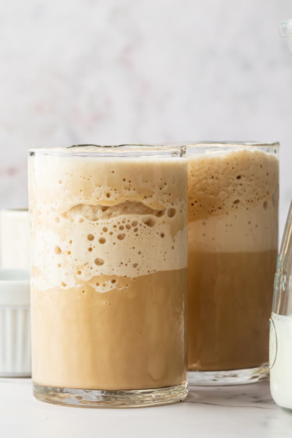 Two glasses on a countertop containing homemade McDonald's mocha frappe.