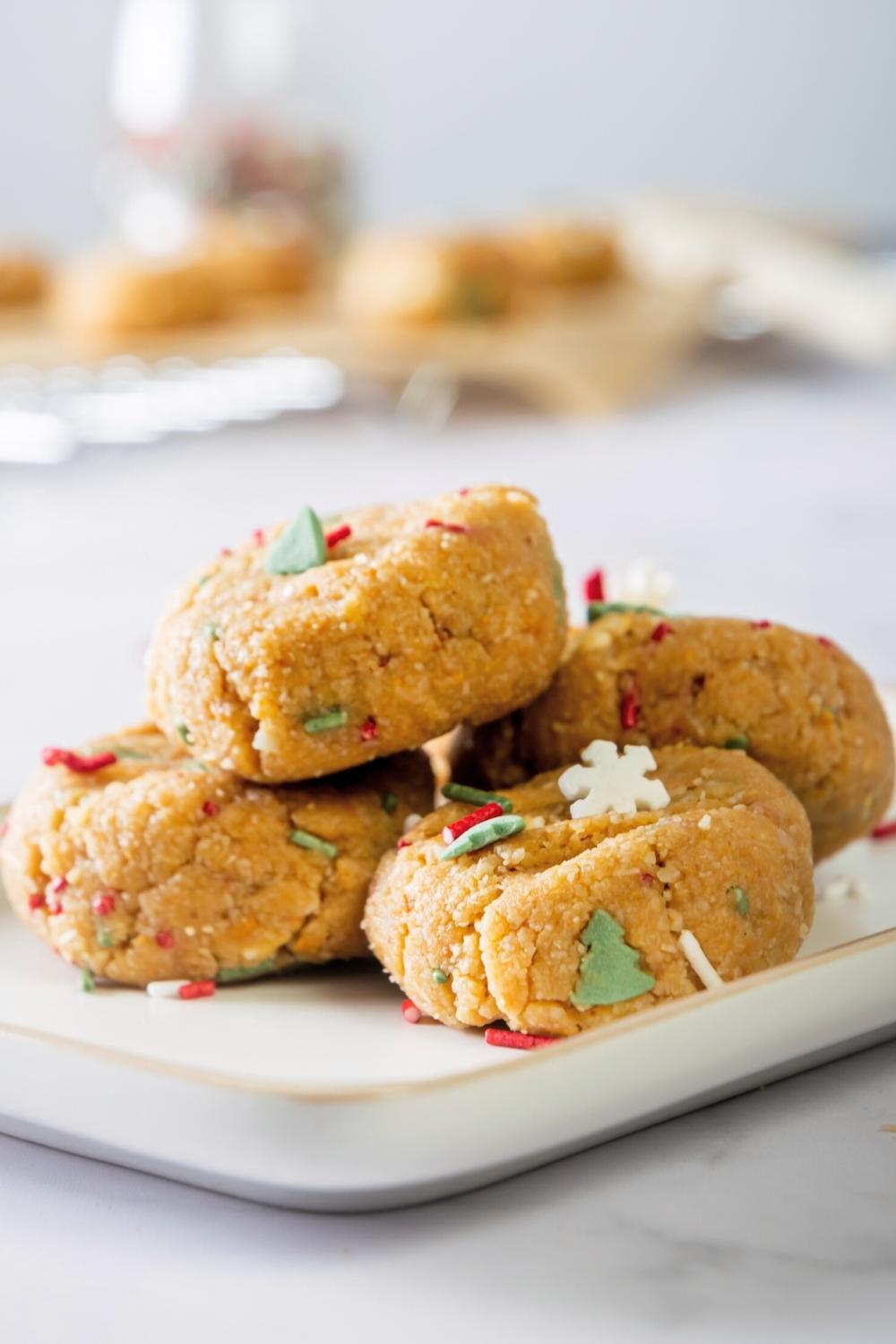 Four no bake christmas cookies overlapping one another on a white plate.