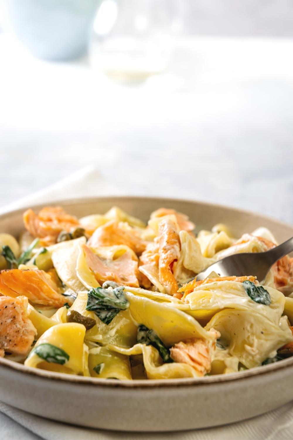 Creamy salmon pasta in part of a bowl.