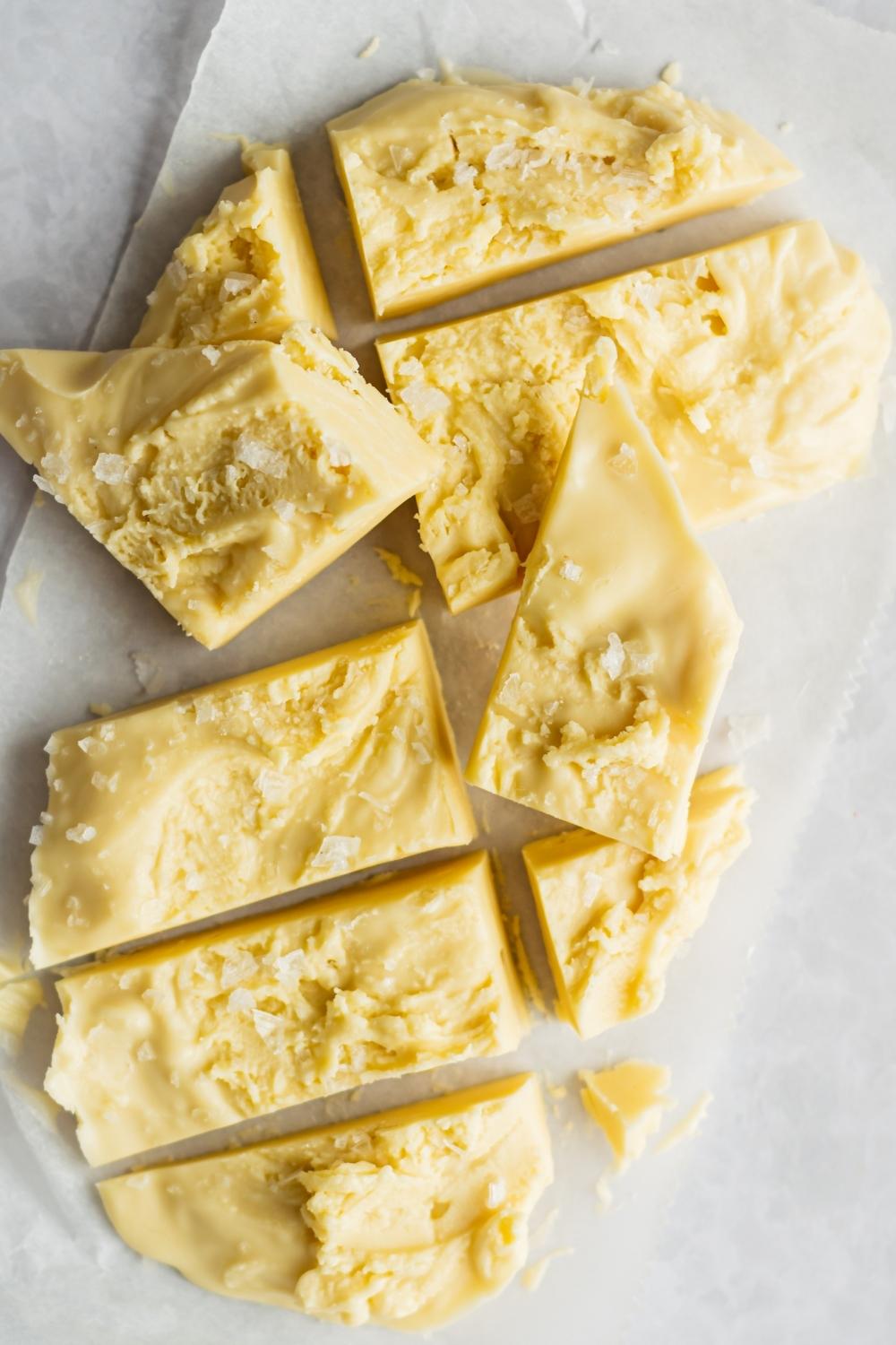 A close-up of homemade maple fudge cut into pieces topped with sea salt.