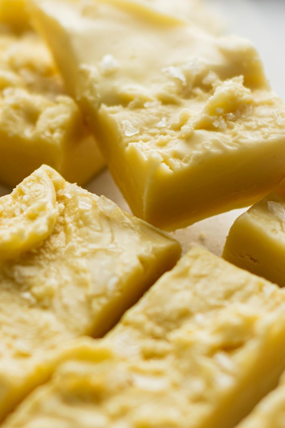 A close-up of homemade maple fudge cut into pieces topped with sea salt.