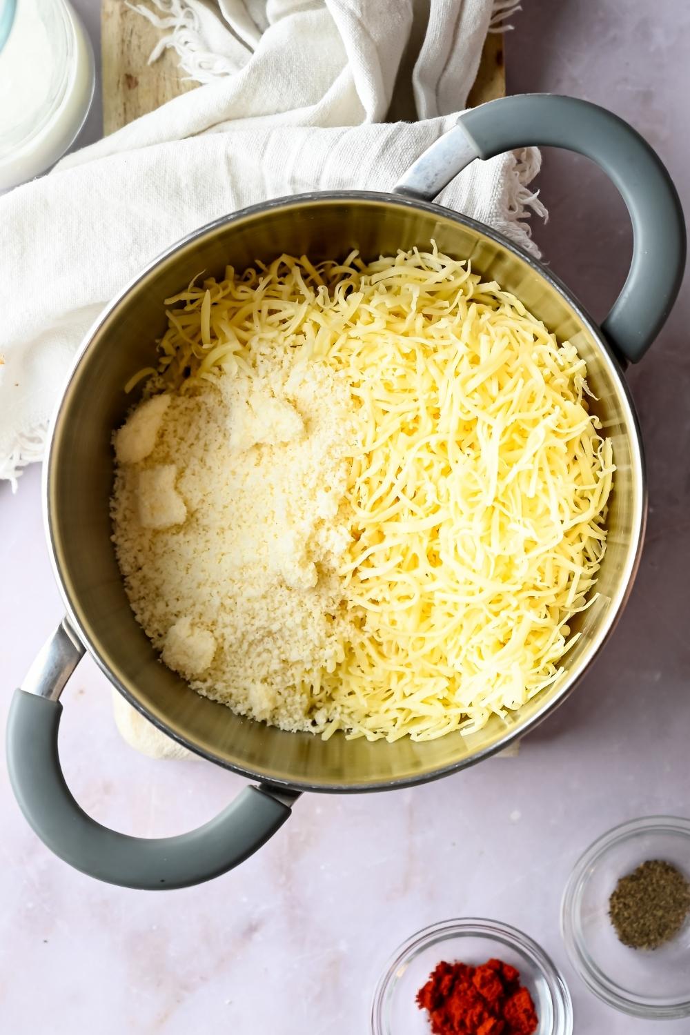 An overhead view of a medium pot with a blend of cheeses.
