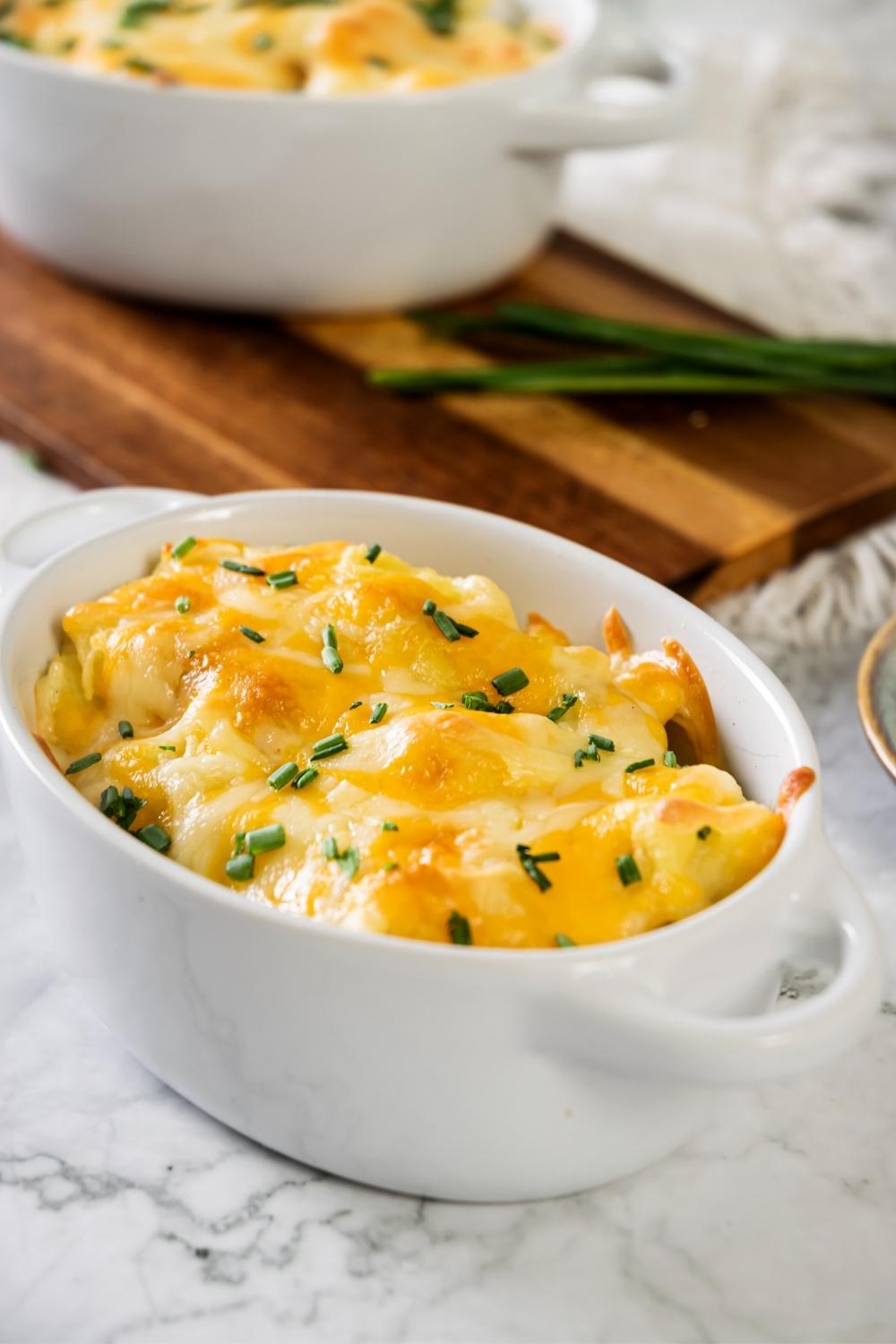 Cheesy mashed potatoes in a white casserole dish.