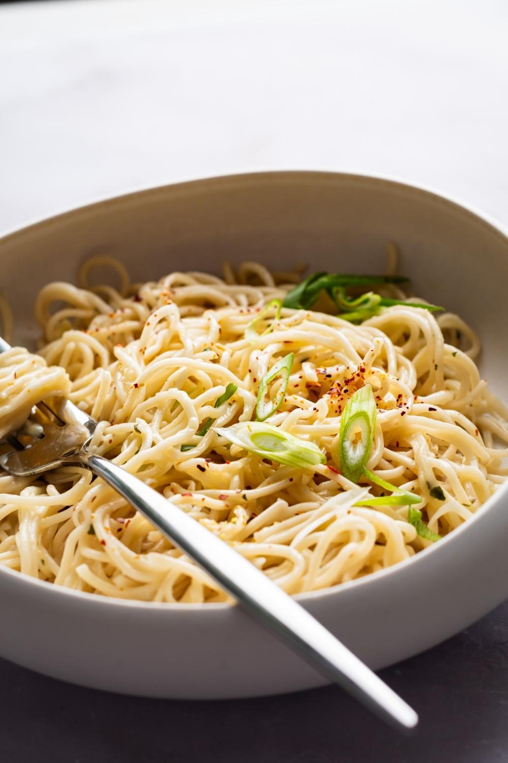 a bowl of cheesy ramen with a fork