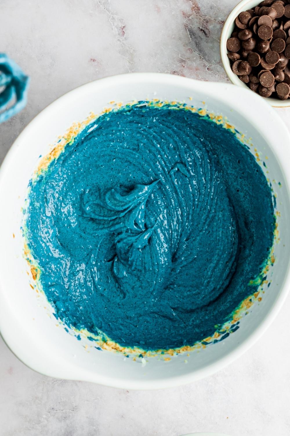 A mixing bowl with blue cookie monster cookie batter