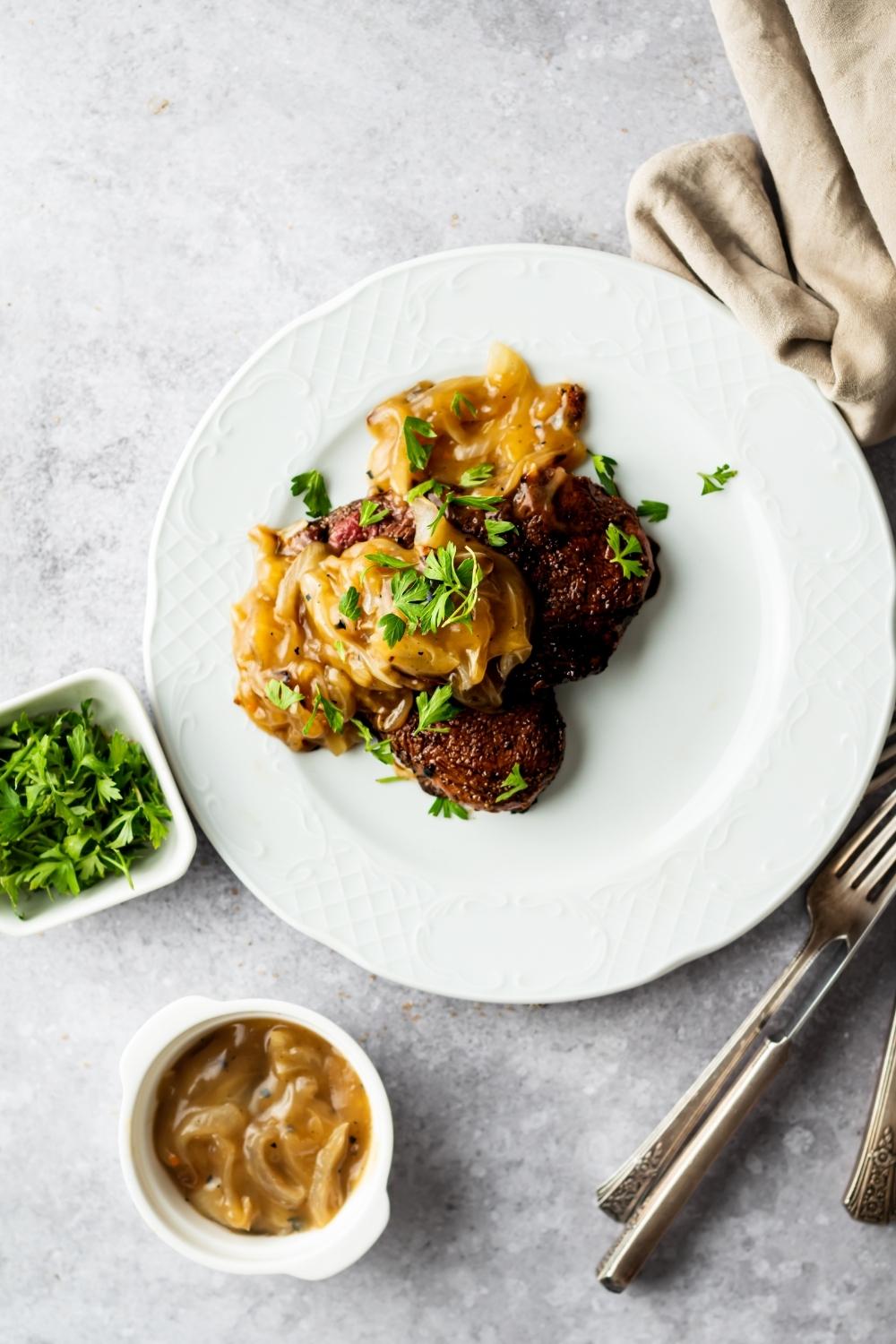flat lay of seared cubed steaks topped with onion gravy and parsley