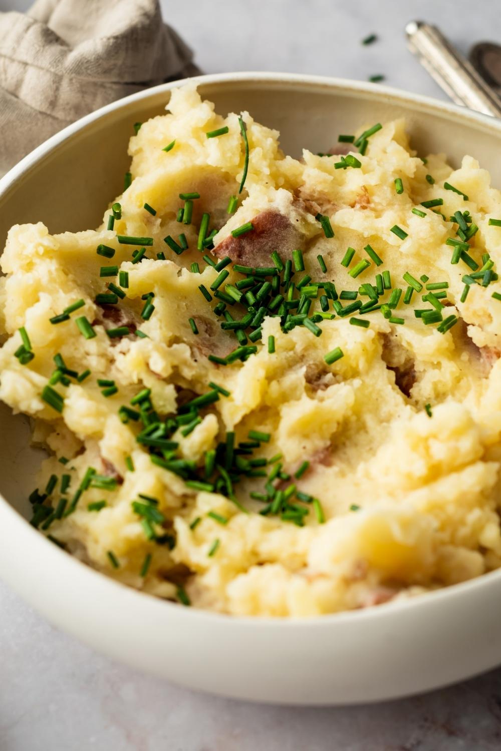 Part of a white ball that is filled to the top with Redskin mashed potatoes.