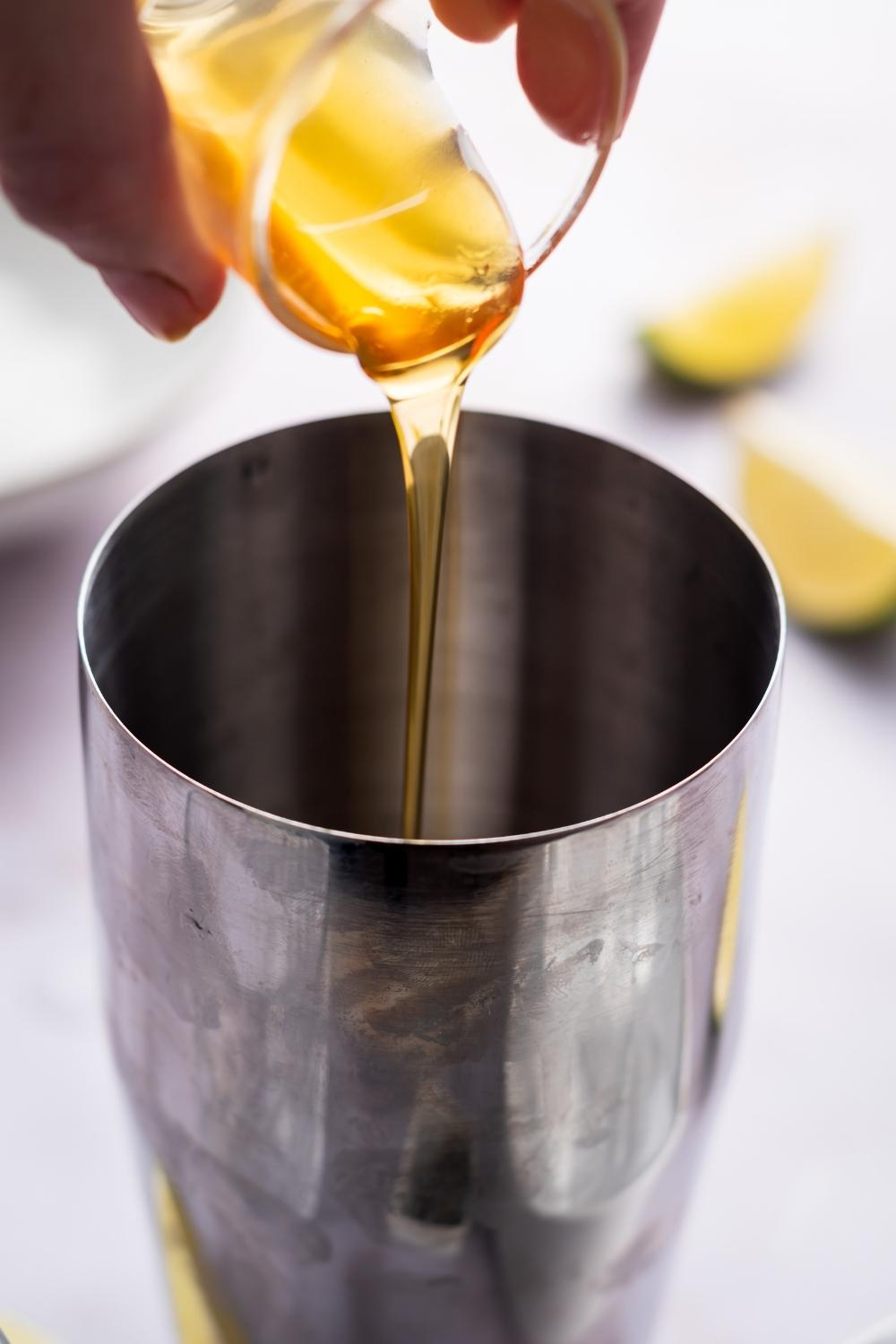 orange liqueur being poured into a shaker