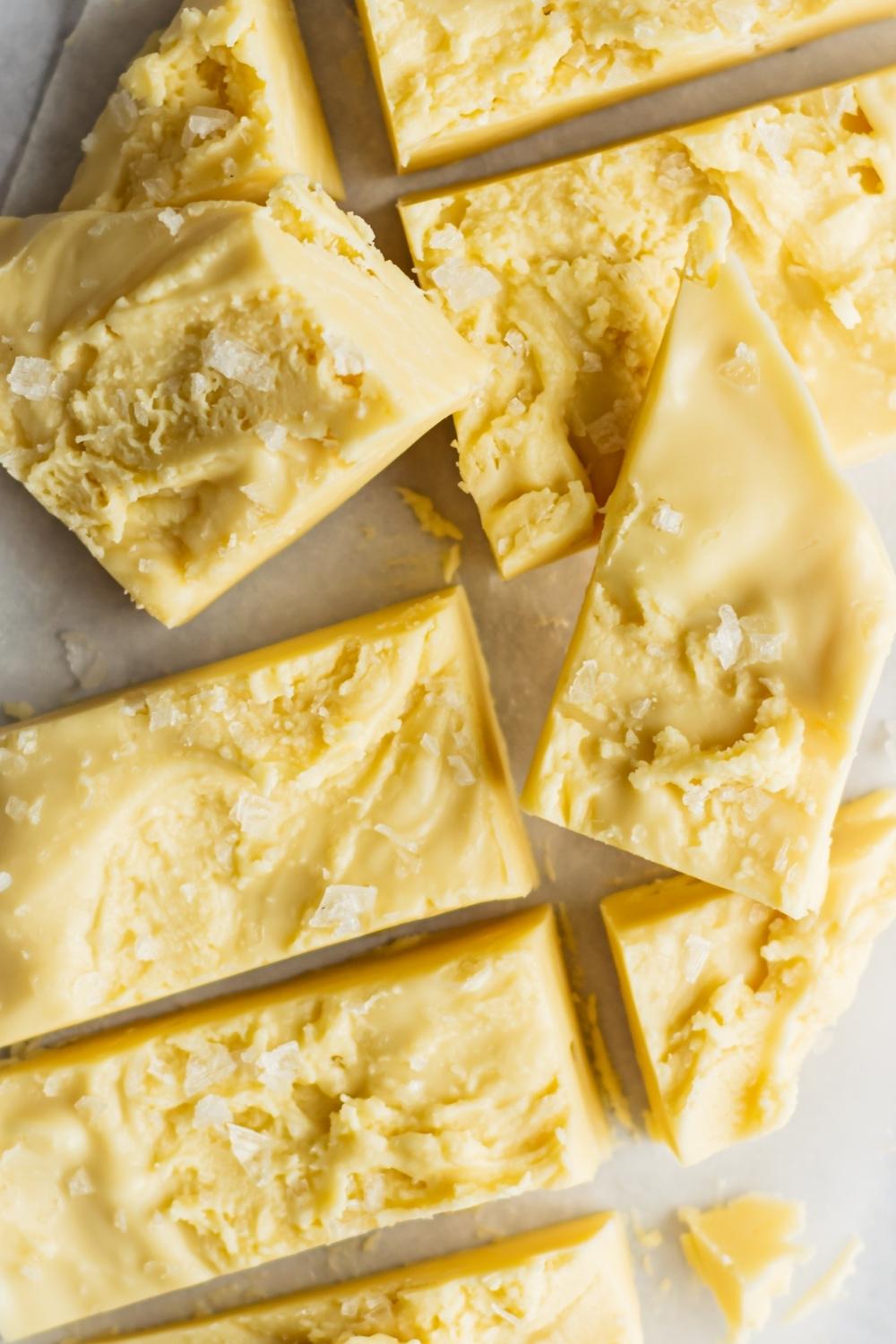 A close-up of homemade maple fudge cut into pieces topped with sea salt.