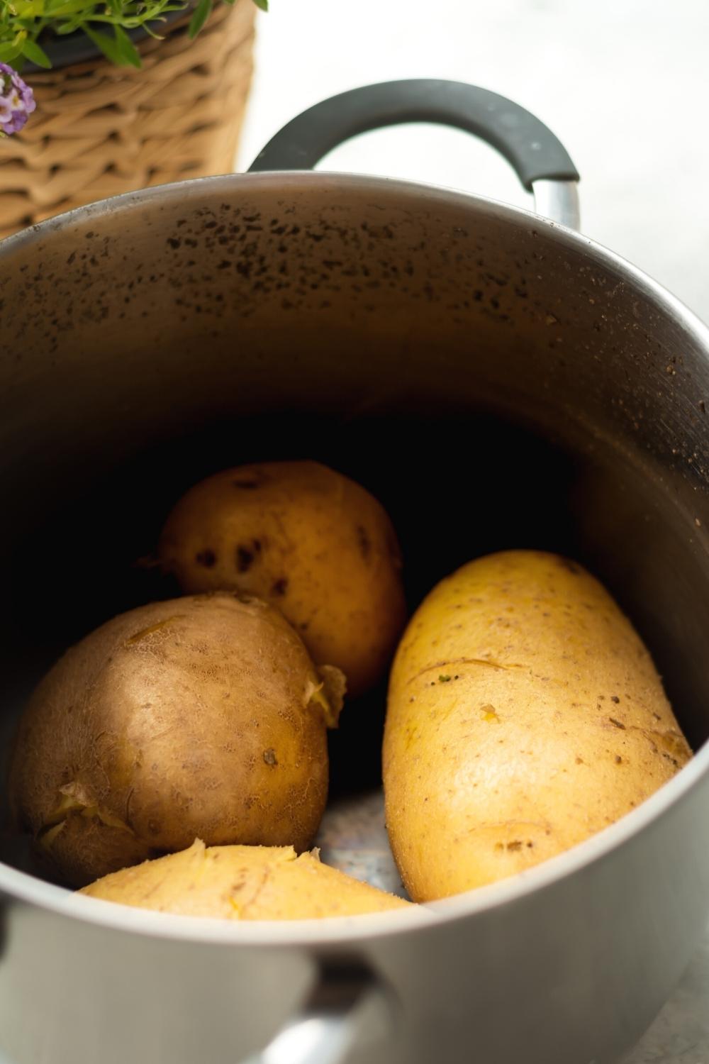 Four potatoes in a pot.