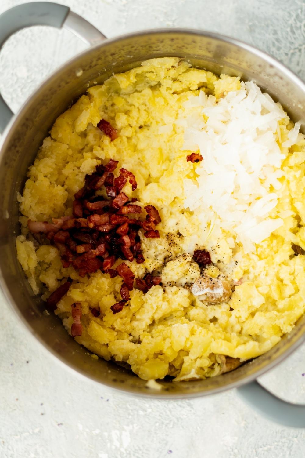 A pot that is filled with bacon and cheese on top of mashed potatoes.