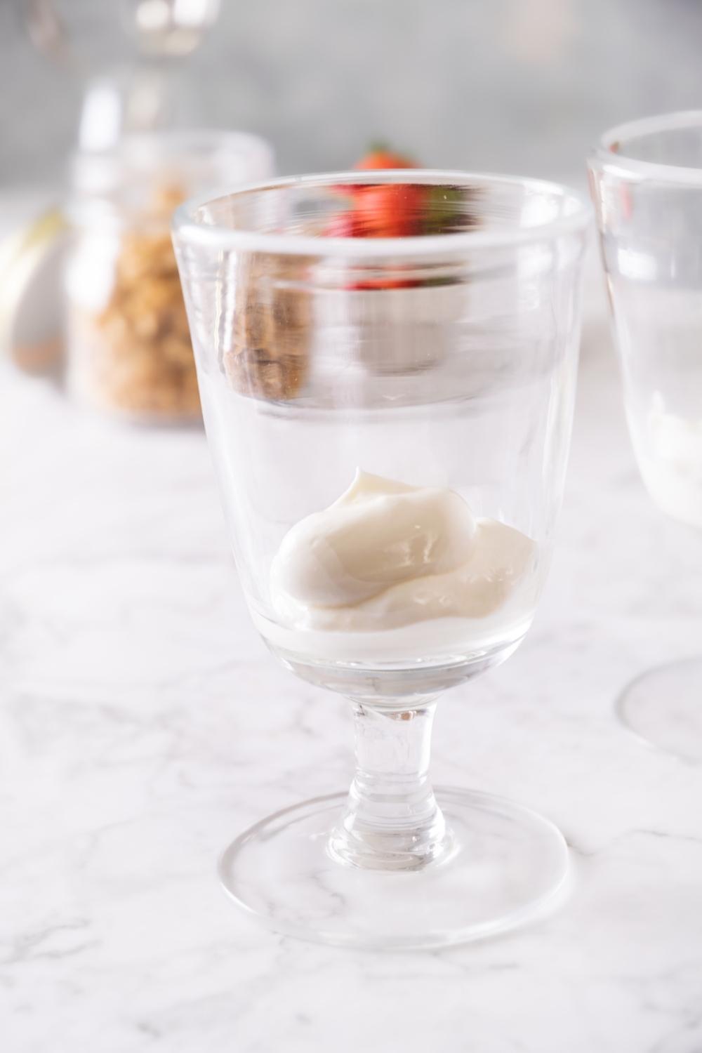 parfait glass with a layer of yogurt at the bottom