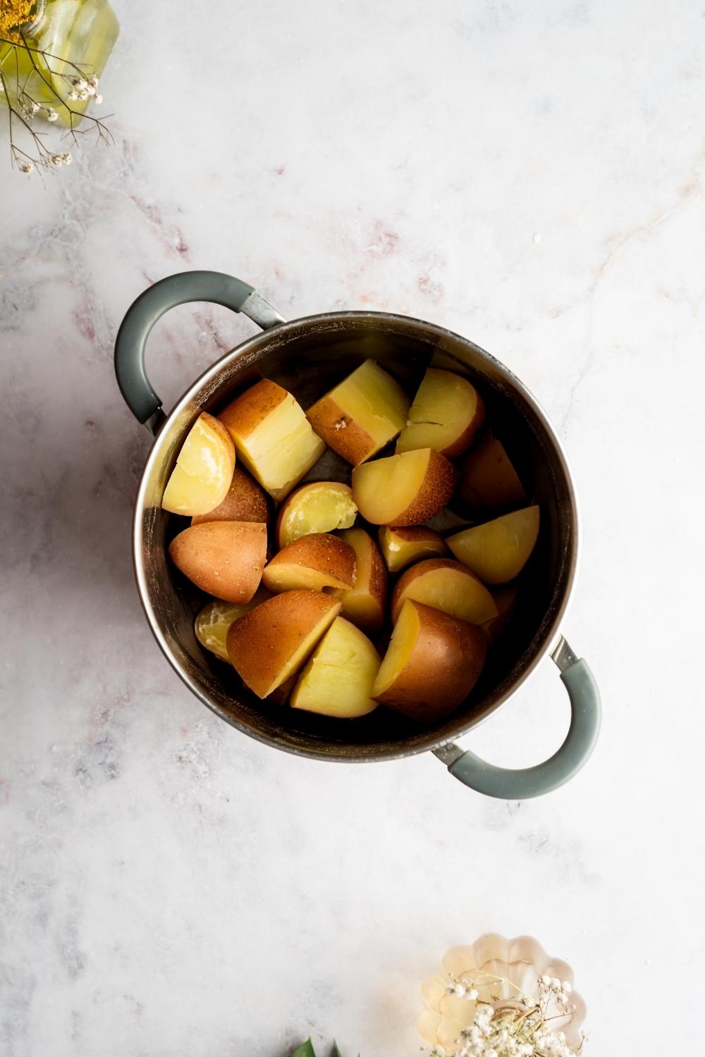 Sliced red skin potatoes in a pot.