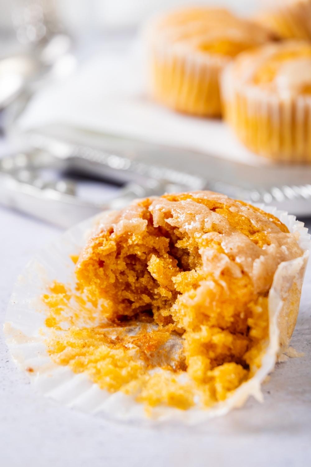 A sweet potato muffin with a bite out of it in a muffin liner.