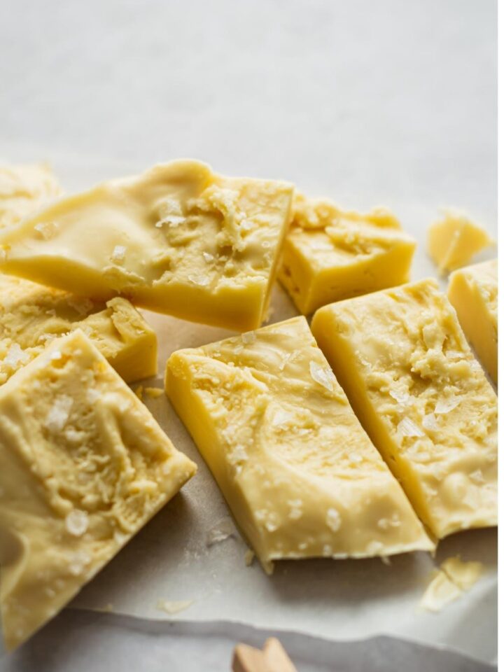 A close-up of homemade maple fudge cut into pieces topped with sea salt.