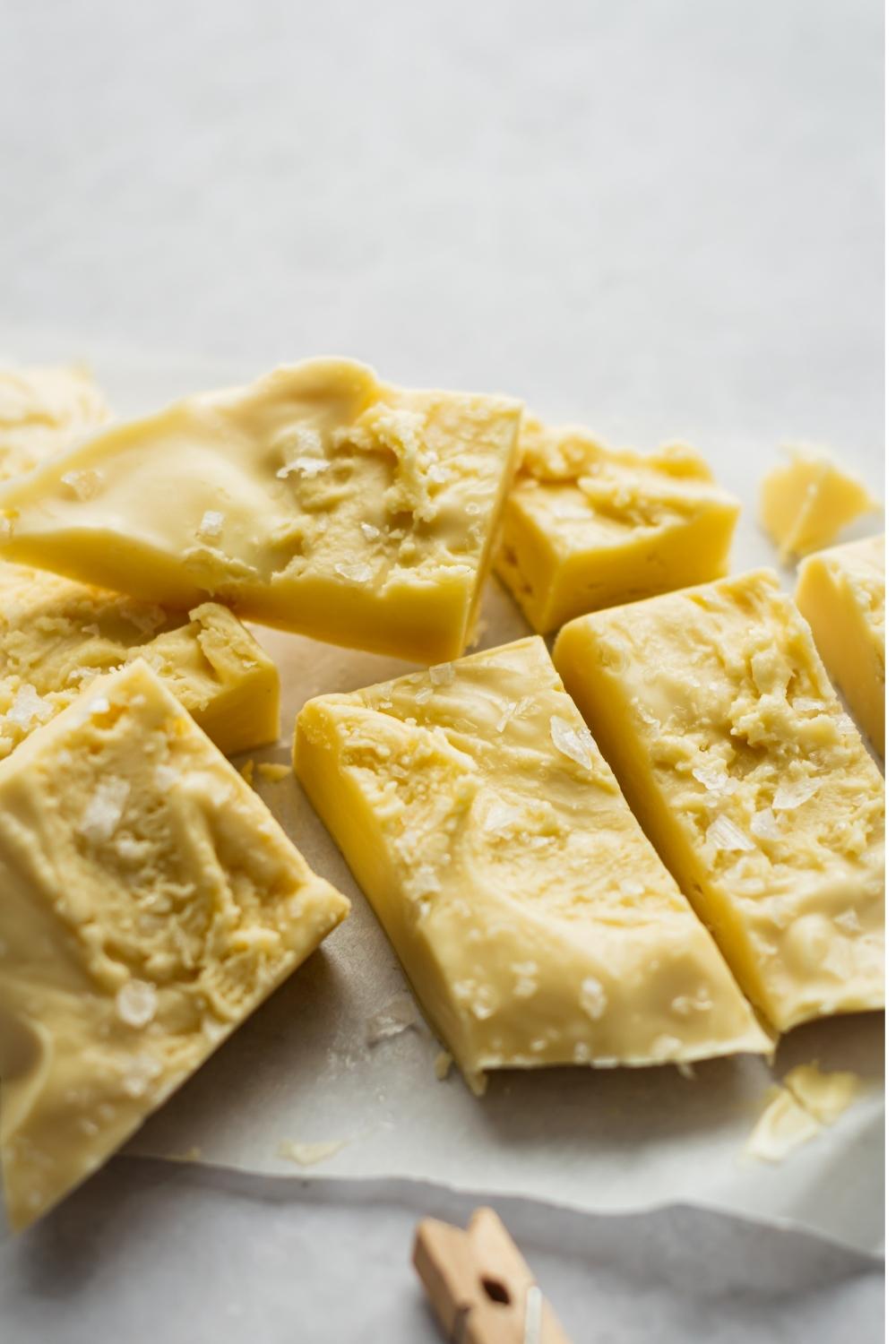 A close-up of homemade maple fudge cut into pieces topped with sea salt.