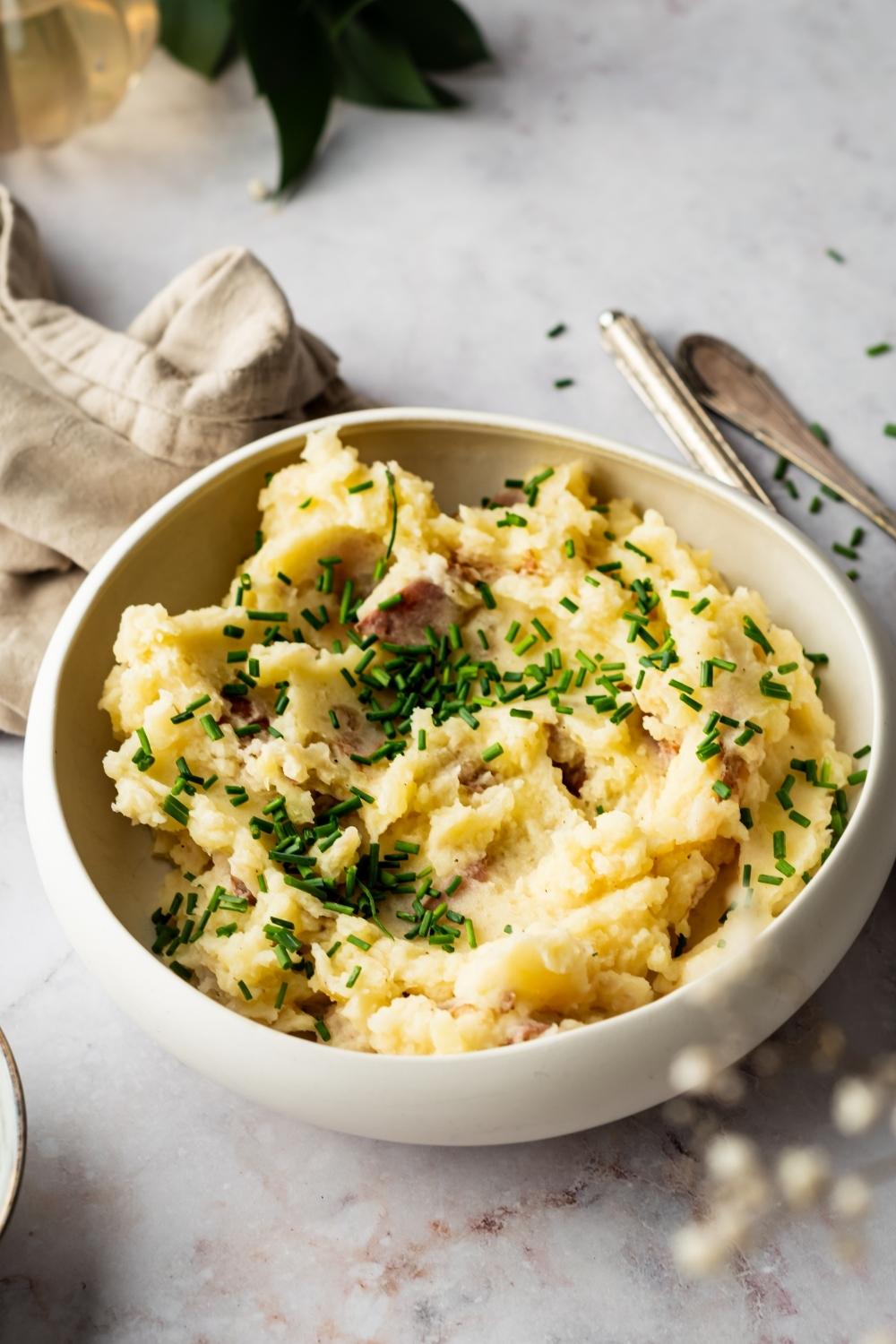 A white bowl that is filled with Redskin mashed potatoes.