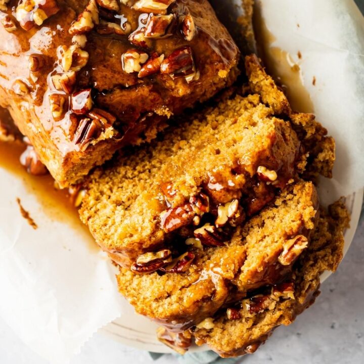 Part of a sweet potato poundcake with three slices in front of it.