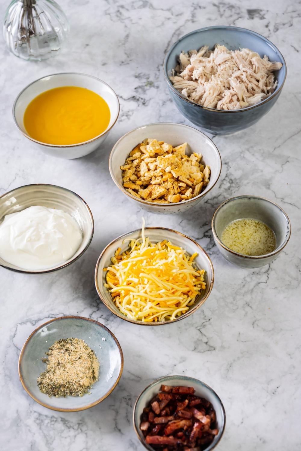 A countertop with bowls containing the ingredients needed to make crack chicken bake.