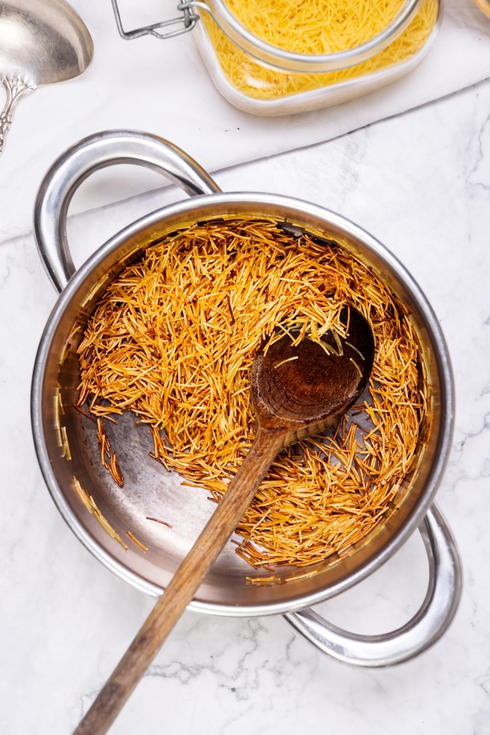 a pot filled with golden toasted angel hair pasta that's been broken up