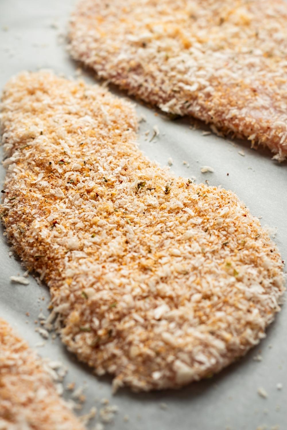 close up shot of uncooked chicken coated in an even layer of panko breading