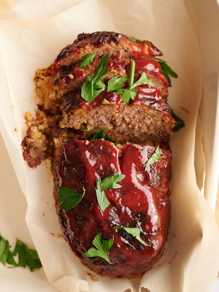 A southern meatloaf on a sheet of parchment paper in a baking dish.