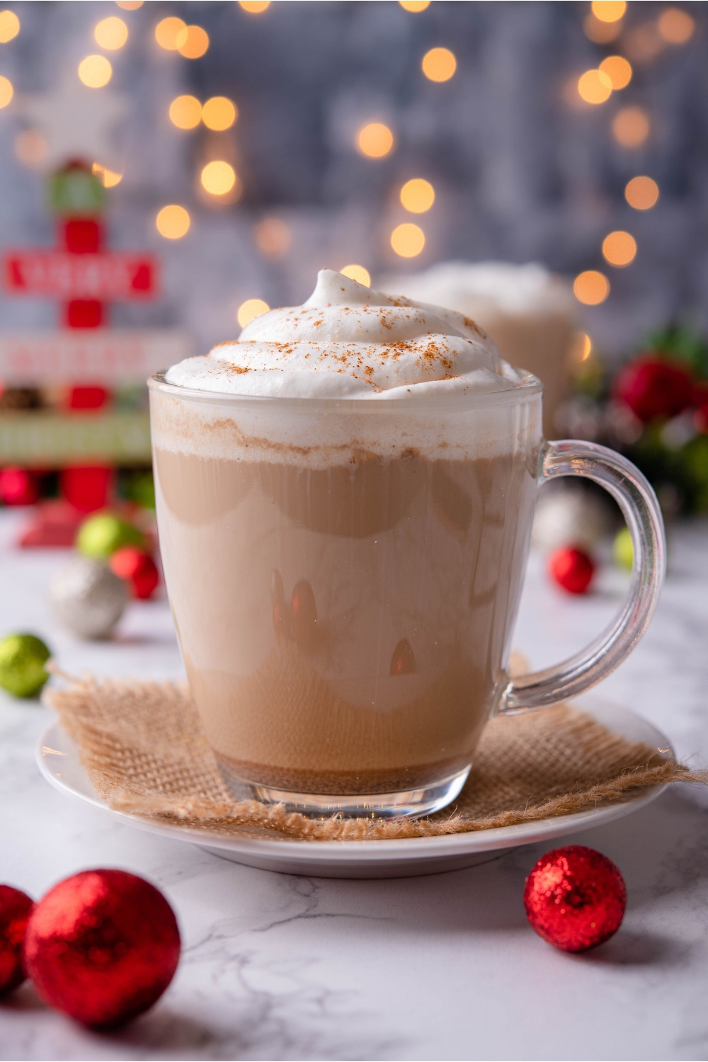 Gingerbread latte in clear mug topped with whipped cream.