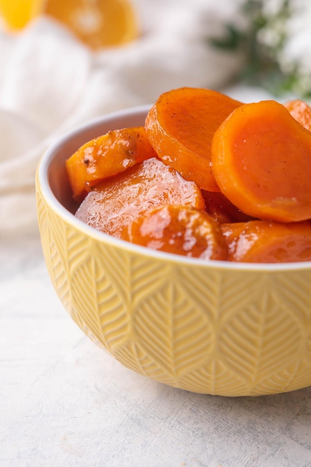 A bowl with candied yams in it.