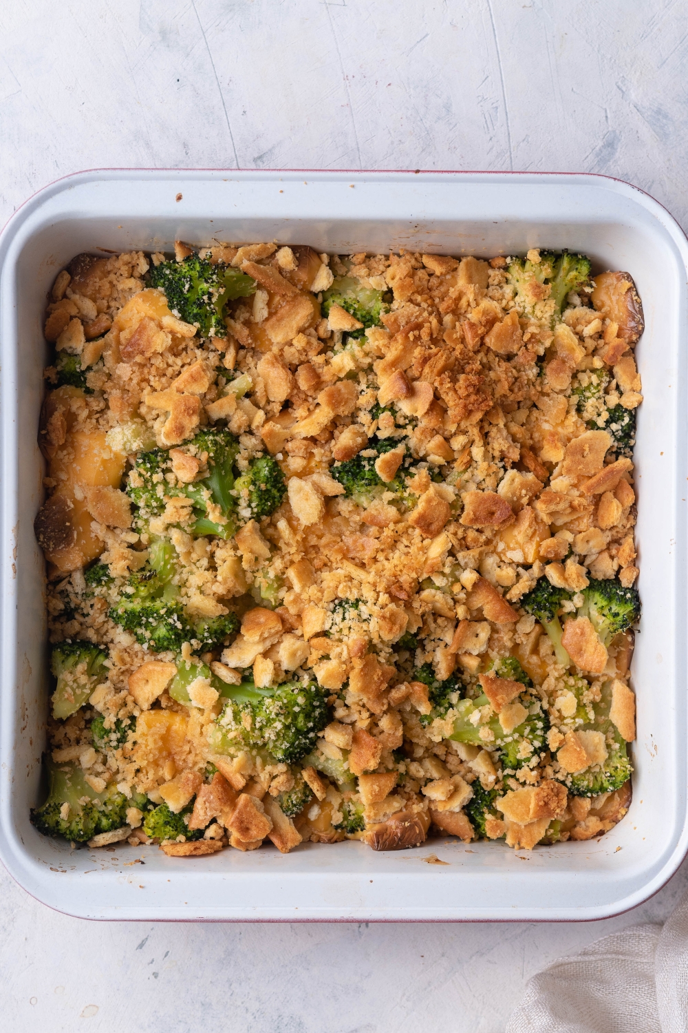 An overhead view of a casserole dish with cooked broccoli cheese casserole.