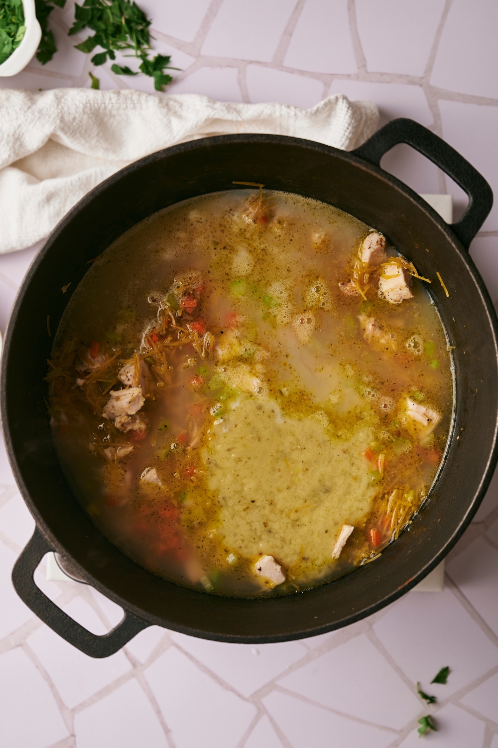 A dutch oven with the ingredients for crack chicken soup cooking.