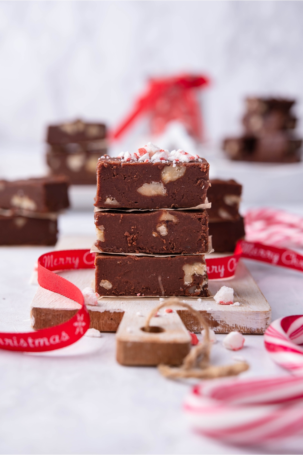 Fantasy fudge squares stacked on top of one another on a wooden board.